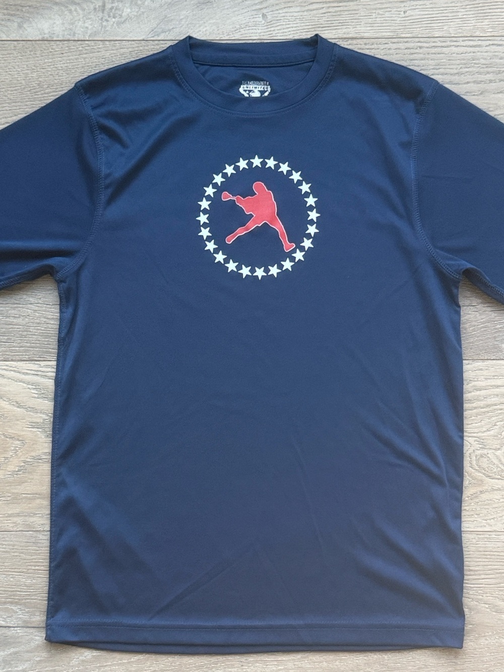 Lacrosse Unlimited Navy Performance Tee w/ White Stars & Red LAX Athlete Graphic